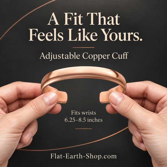 Hands holding both ends of a smooth copper-colored open cuff bracelet.