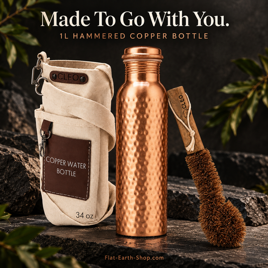 Hammered Copper Water Bottle — 1L — main product view on dark slate with warm copper lighting.