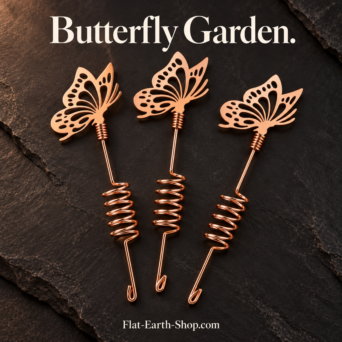 Three copper butterfly garden stakes in a dark setting