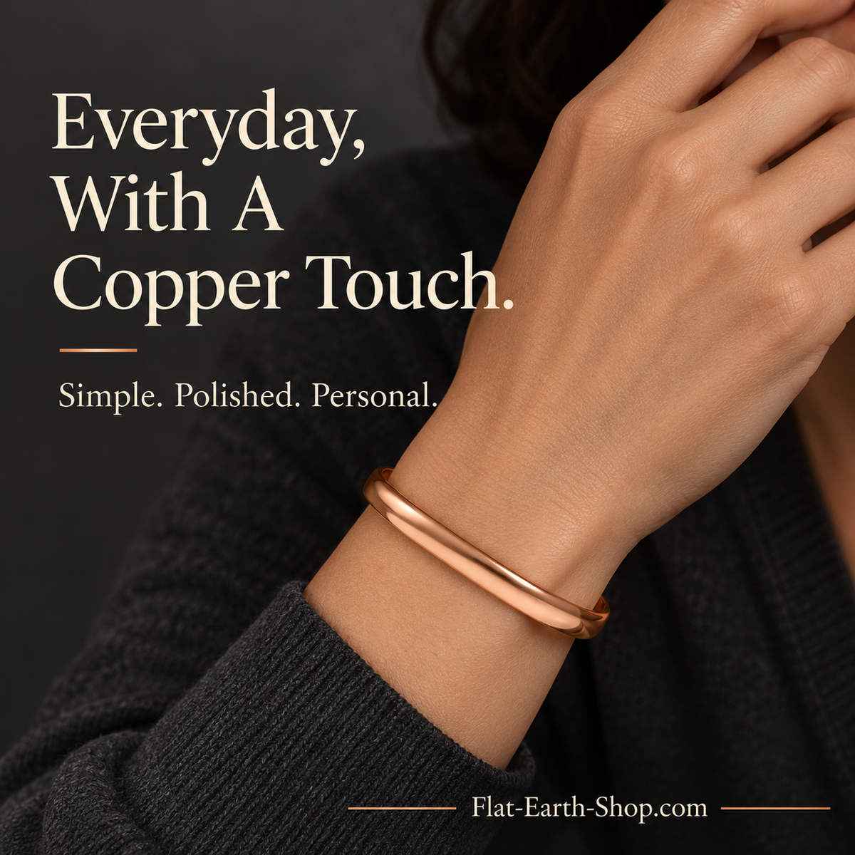 Smooth copper-colored cuff worn on a wrist beside a black knit sleeve.