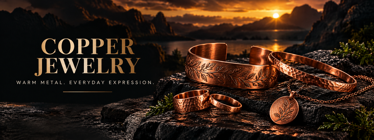 Copper Jewelry — Warm metal. Everyday expression. Copper cuffs, rings, a bangle and a pendant necklace on dark stone.