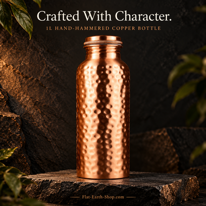 Copper Water Bottle — 1L Hand-Hammered Design — main product view on dark slate with warm copper lighting.