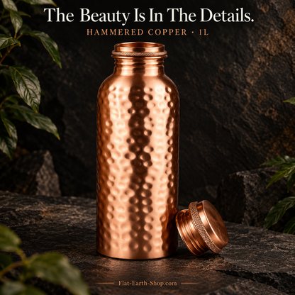 Copper Water Bottle — 1L Hand-Hammered Design — detail product view on dark slate with warm copper lighting.